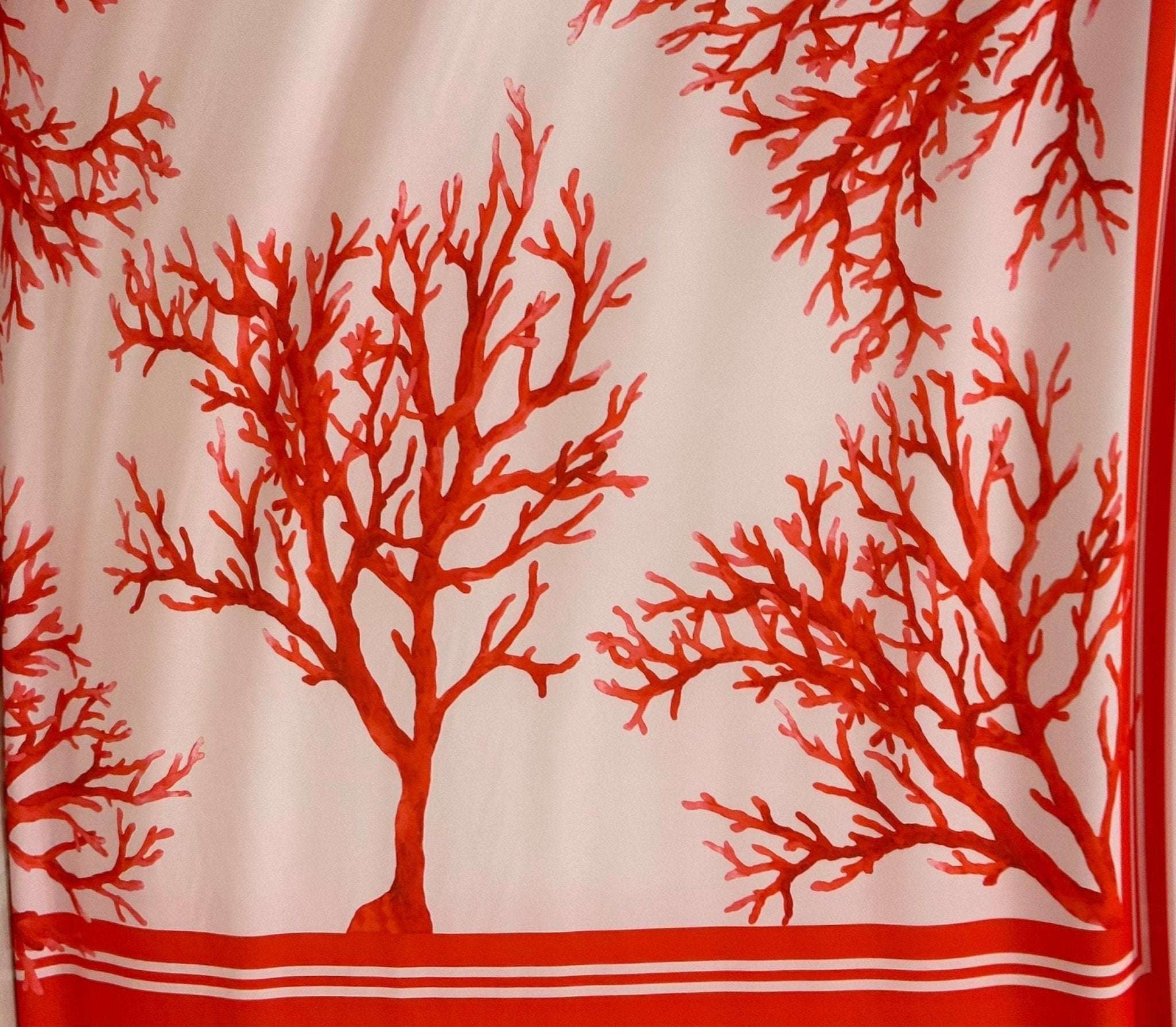 Silky crepe fabric with vibrant red coral pattern on soft pink background, 150cm width