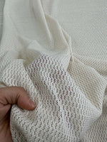 100 cotton off-white fishnet mesh fabric held by hand showing soft open weave texture for crafting and apparel