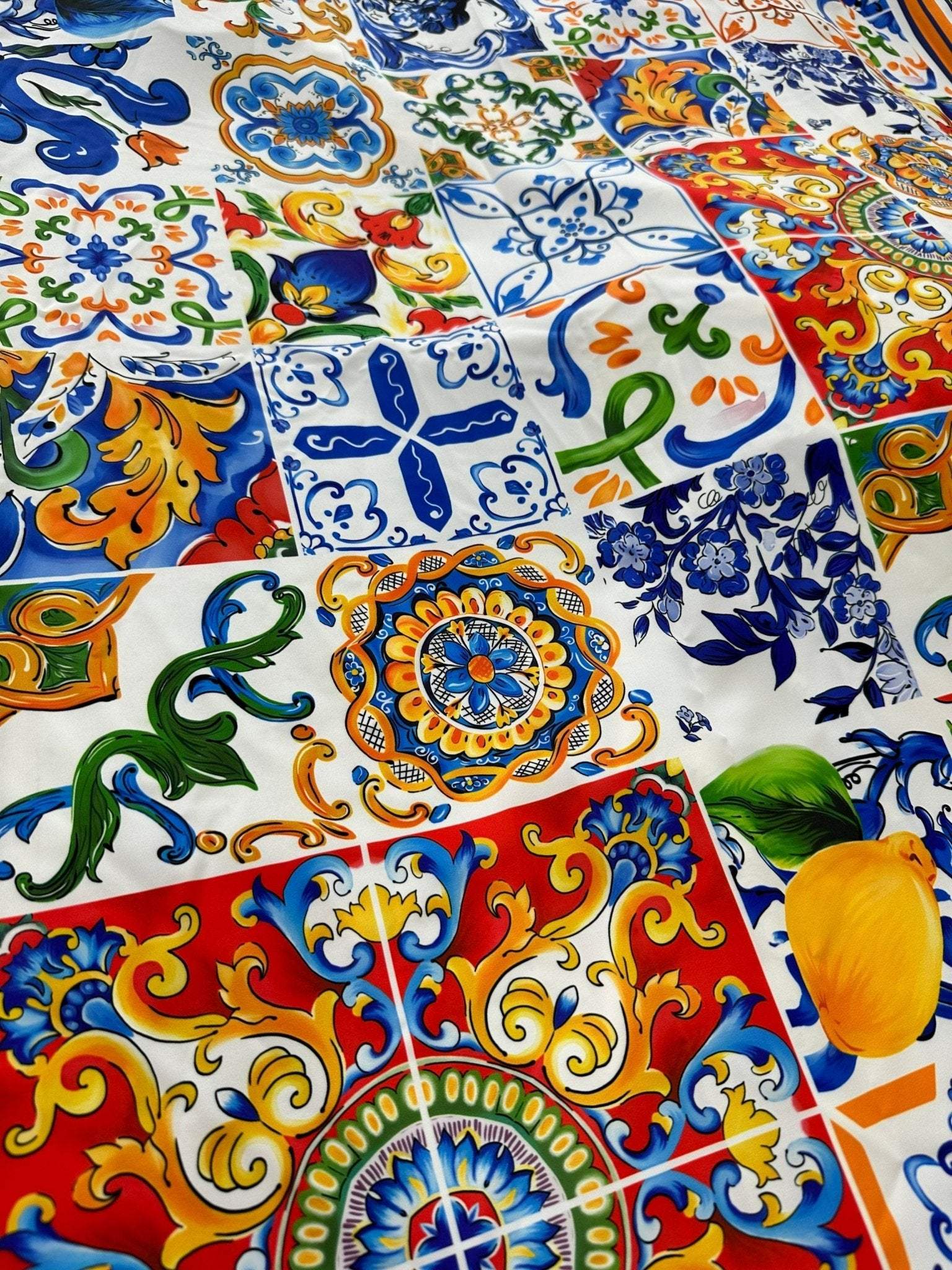 Sicilian Print Silky Crepe Fabric with colorful intricate Mediterranean patterns in blue, red, yellow, and green tones.