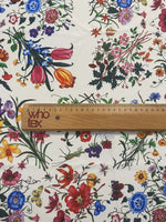 Cream floral botanical print fabric with colorful flowers on a cream background and a wooden ruler for scale
