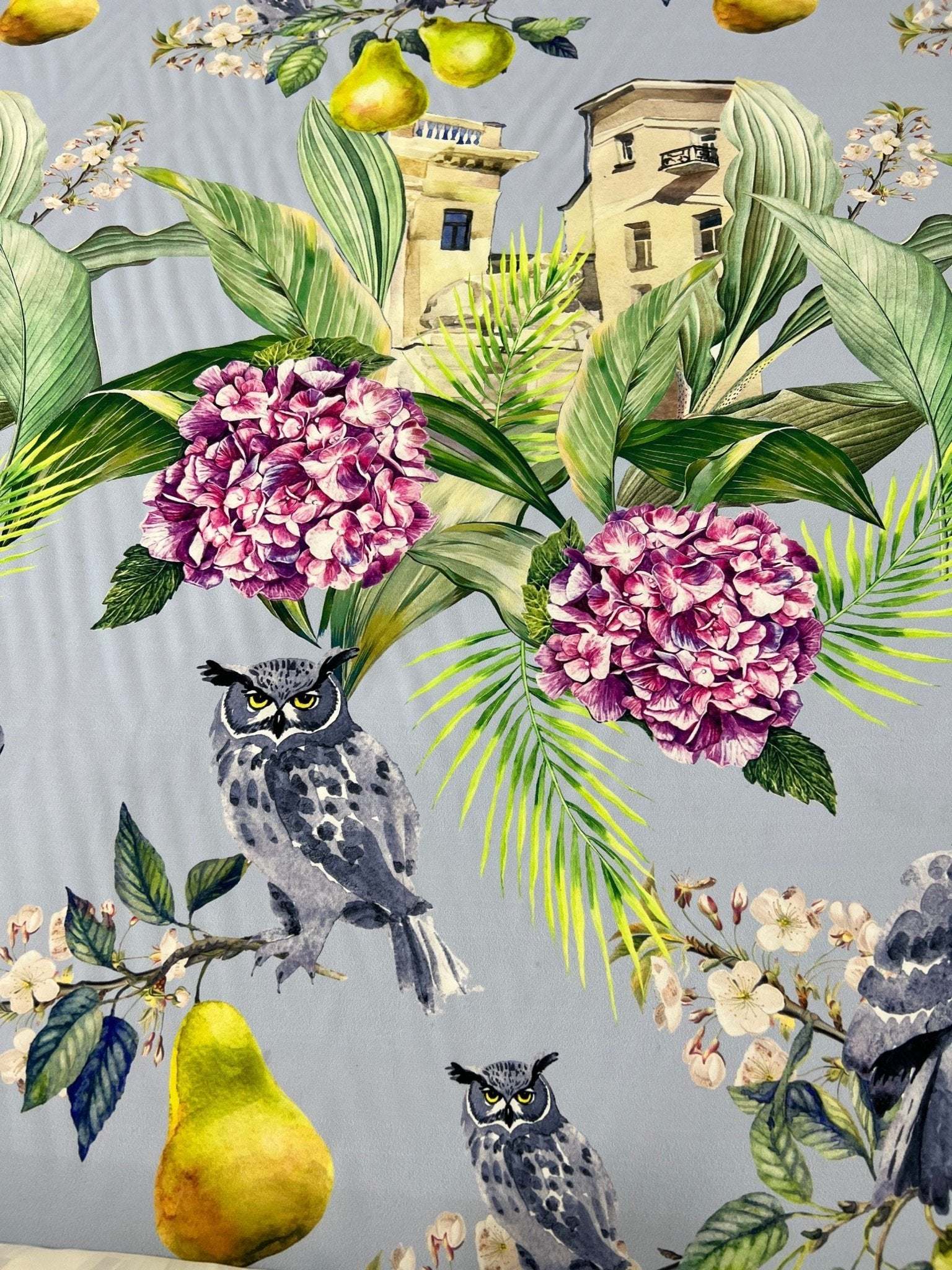 Tropical parrot print crepe fabric with colorful birds, purple flowers, green leaves, and yellow pears on a gray background