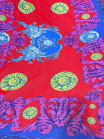 Purple swirl crepe fabric with intricate blue and yellow pattern on red background