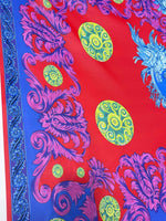 Purple swirl crepe fabric with vibrant purple and yellow patterns on a red and blue background