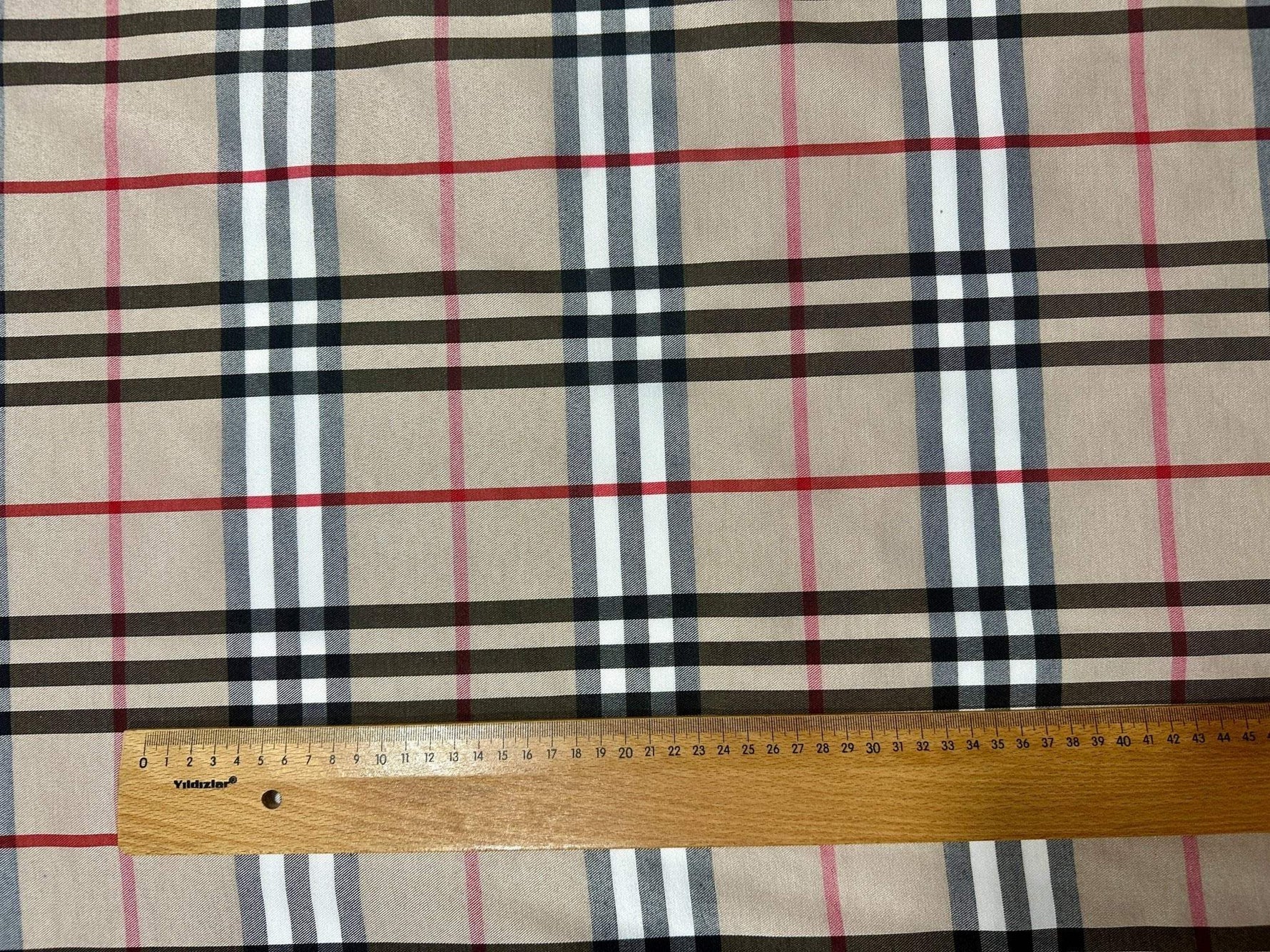 Double sided beige plaid tartan poplin cotton fabric with neutral classic check pattern and ruler for scale