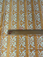 Elegant gold Baroque fabric with floral and scroll patterns and ruler for scale on white background