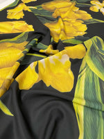 elegant yellow tulip floral print fabric on black background with vibrant yellow tulips and green leaves