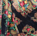 Ethnic floral pattern on soft black velvet lycra fabric with vibrant red, yellow, and blue flowers and intricate paisley designs.