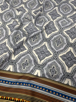 Black and white mandala pattern fabric with ethnic geometric striped border and tribal design