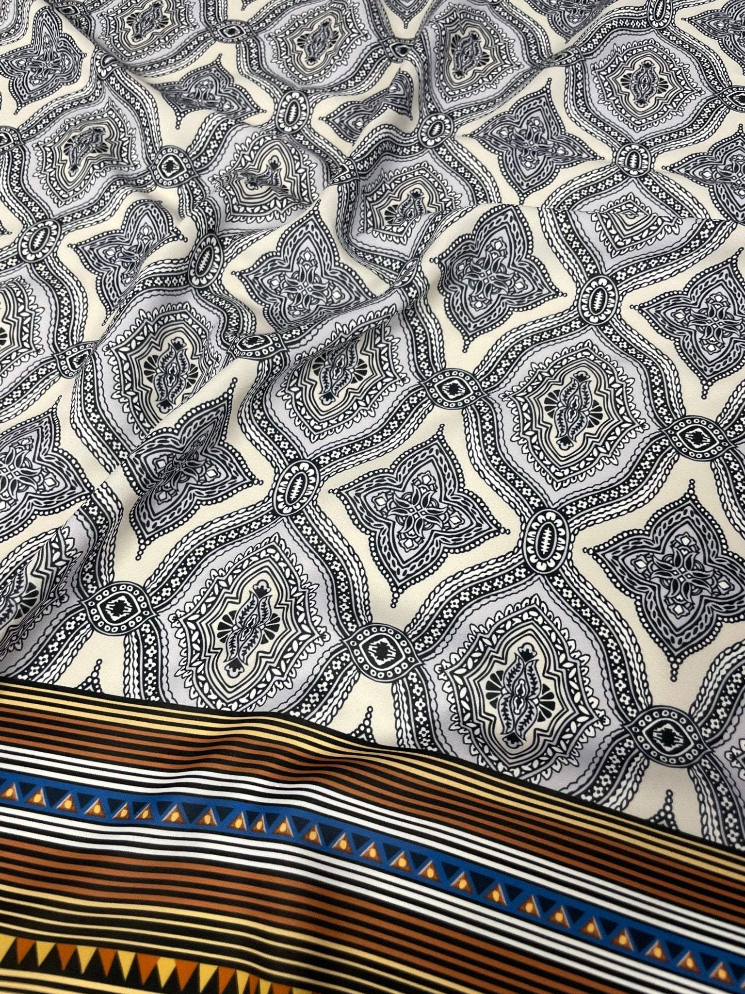 Black and white mandala pattern fabric with ethnic geometric striped border and tribal design