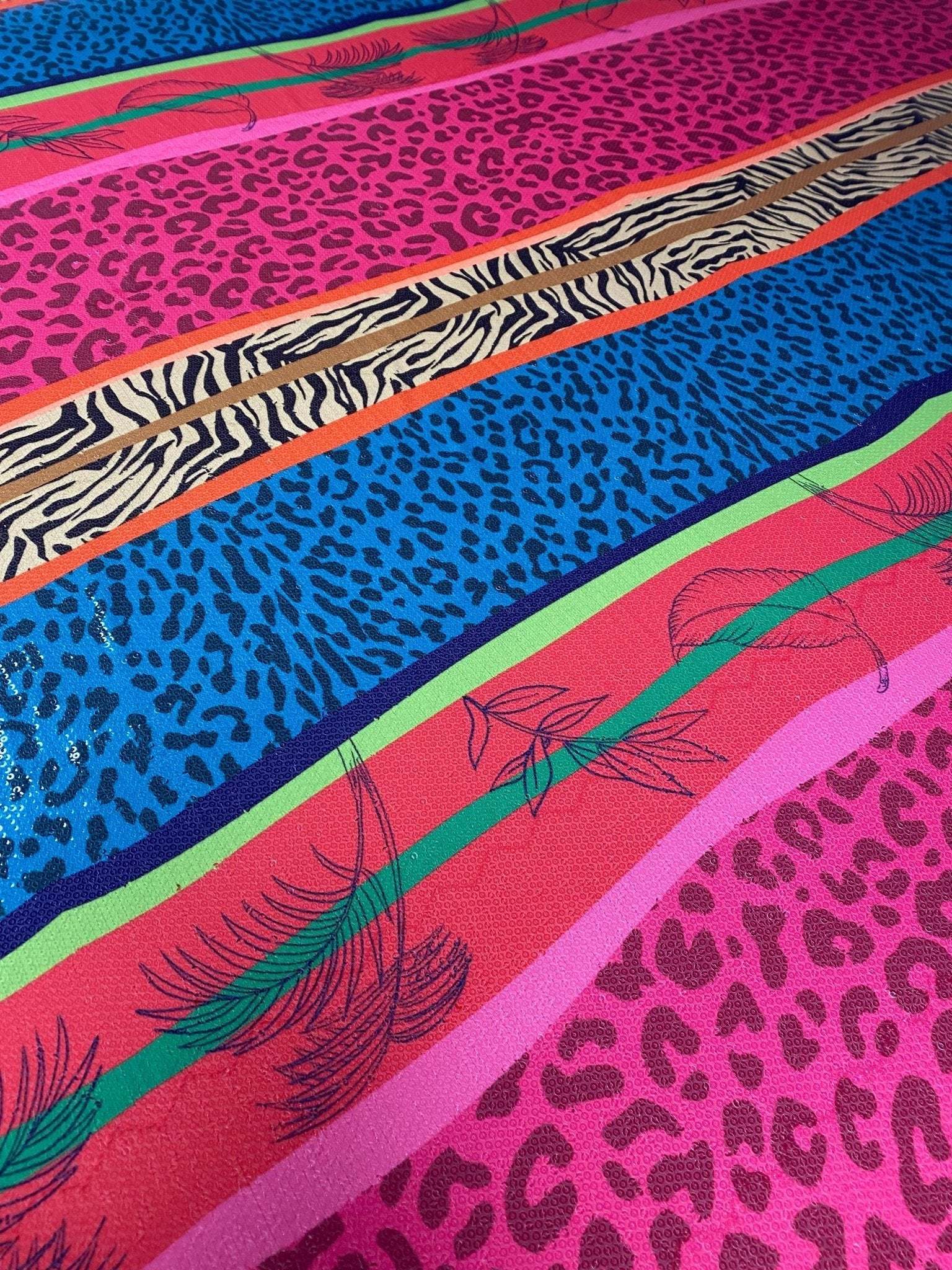 exotic animal print sequin fabric with vibrant pink, blue, and zebra stripe patterns and feather accents