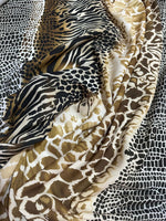 Close-up of exotic animal print fabric with zebra, giraffe, and snakeskin patterns in black, brown, and beige tones