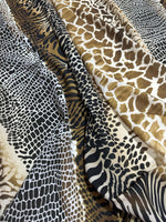 Close-up of exotic animal print fabric featuring various patterns in brown, black, and white tones with a soft, durable texture.