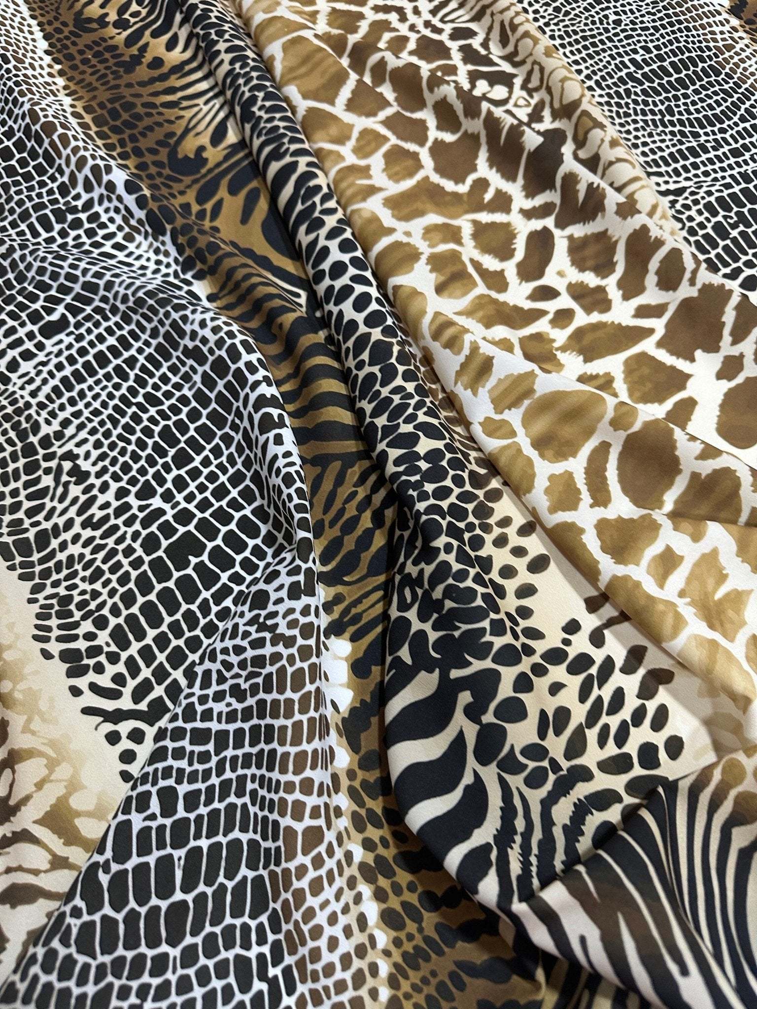 Close-up of exotic animal print fabric featuring various patterns in brown, black, and white tones with a soft, durable texture.