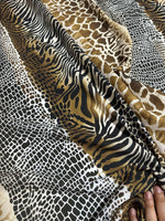 Exotic animal print fabric featuring zebra, giraffe, and snake patterns in brown, black, and beige tones with a soft texture.