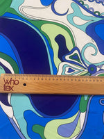 Blue and green floral fabric with retro swirl pattern and wooden ruler for scale