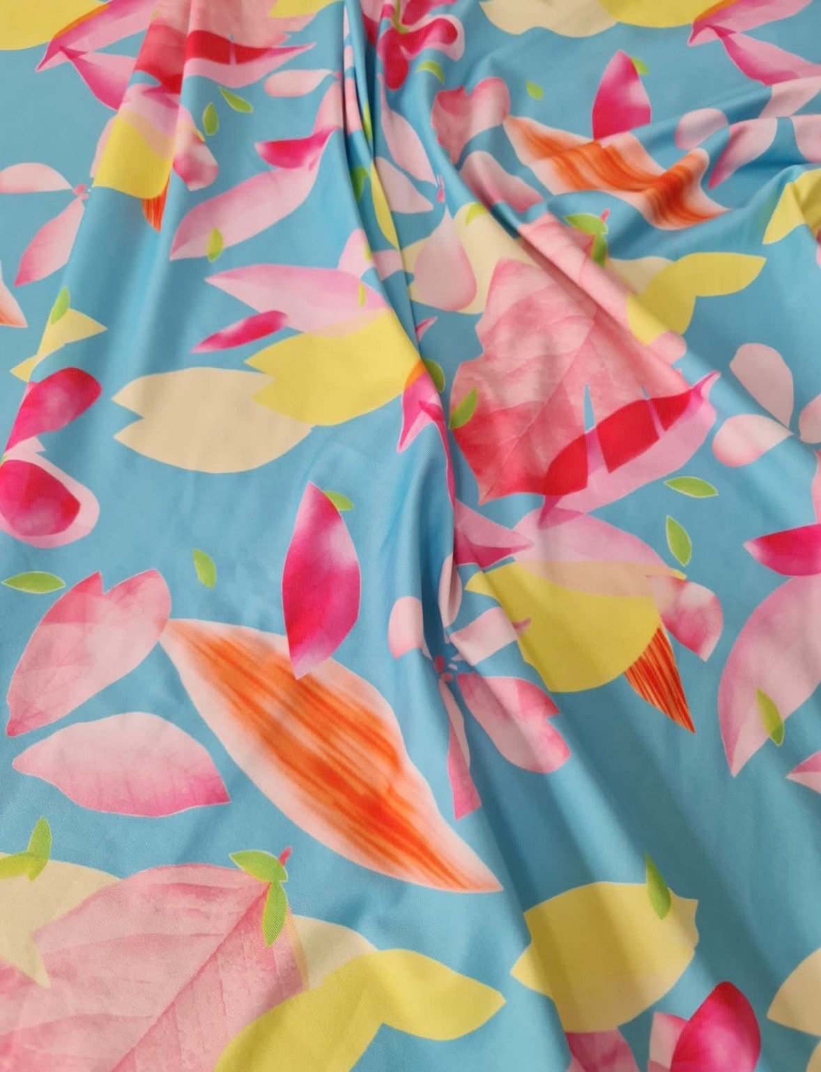Soft cotton floral print fabric with colorful petals on blue background