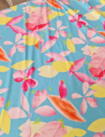 Soft cotton floral print fabric with pink, yellow, and orange flowers on a light blue background