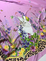 Pink fabric with rabbit print and colorful floral pattern featuring butterflies and leopard print border