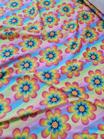 Rainbow floral fabric with colorful flower patterns on a vibrant background, ideal for sewing projects