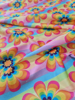 colorful rainbow floral fabric with vibrant multi-colored flower pattern and pastel stripes