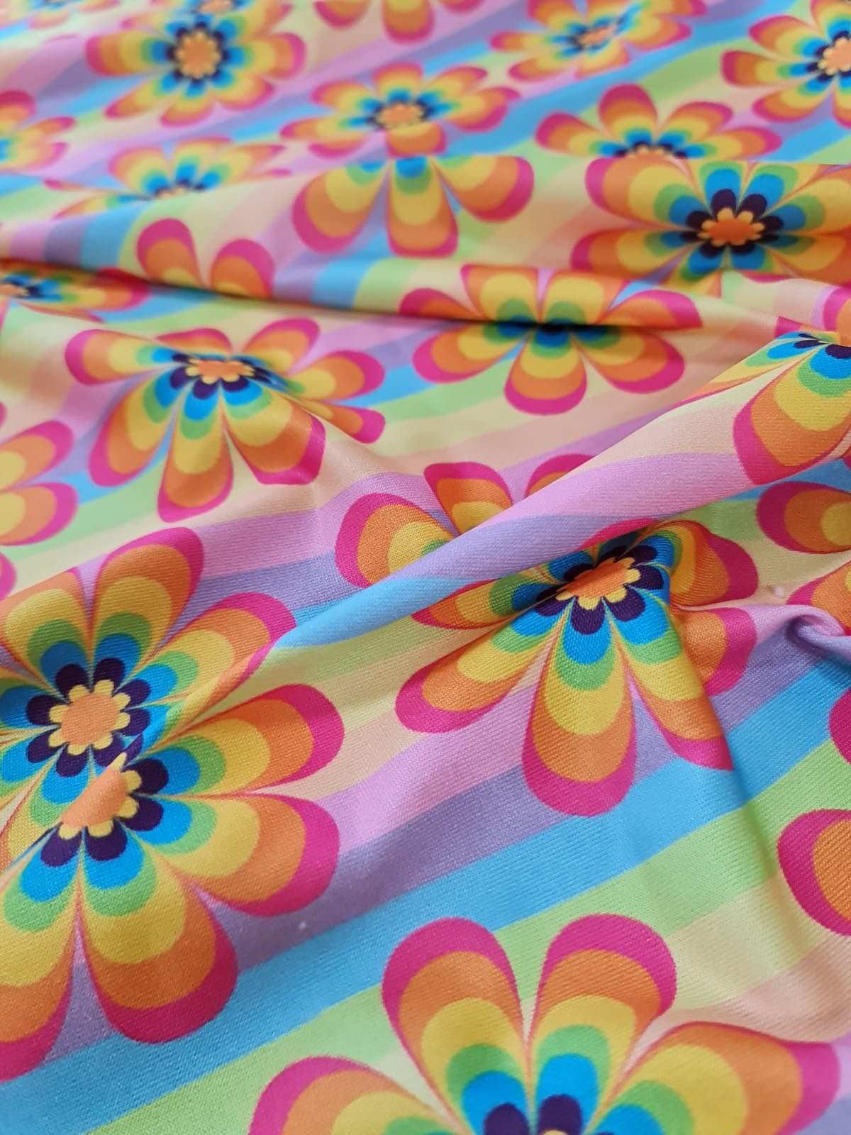 colorful rainbow floral fabric with vibrant multi-colored flower pattern and pastel stripes
