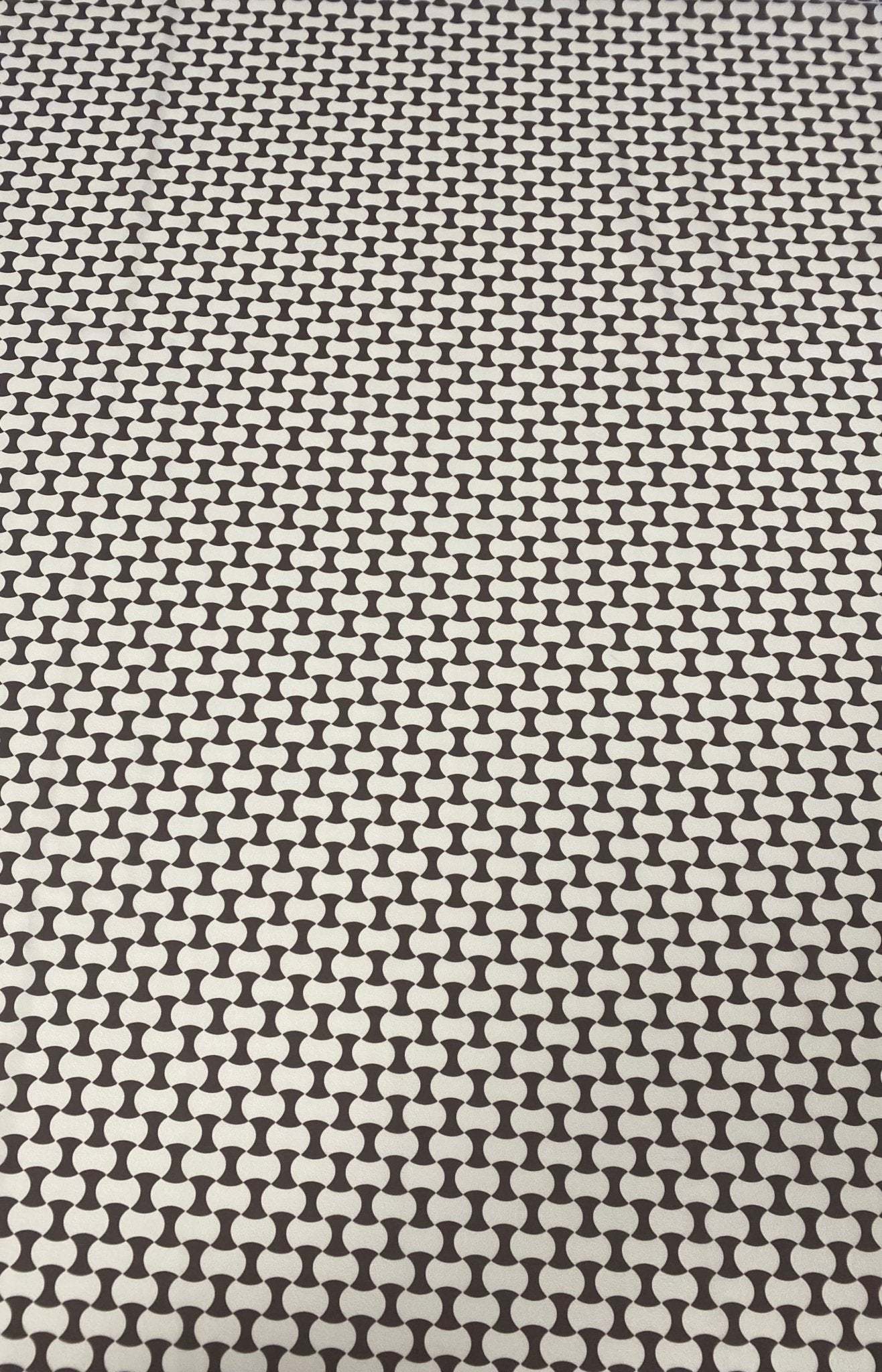 Close-up of geometric black and white optical illusion fabric with repeating shapes and high-quality texture