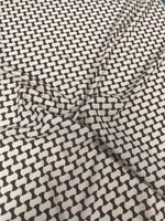 Close-up of geometric black and white optical illusion fabric with interlocking wave pattern and soft texture