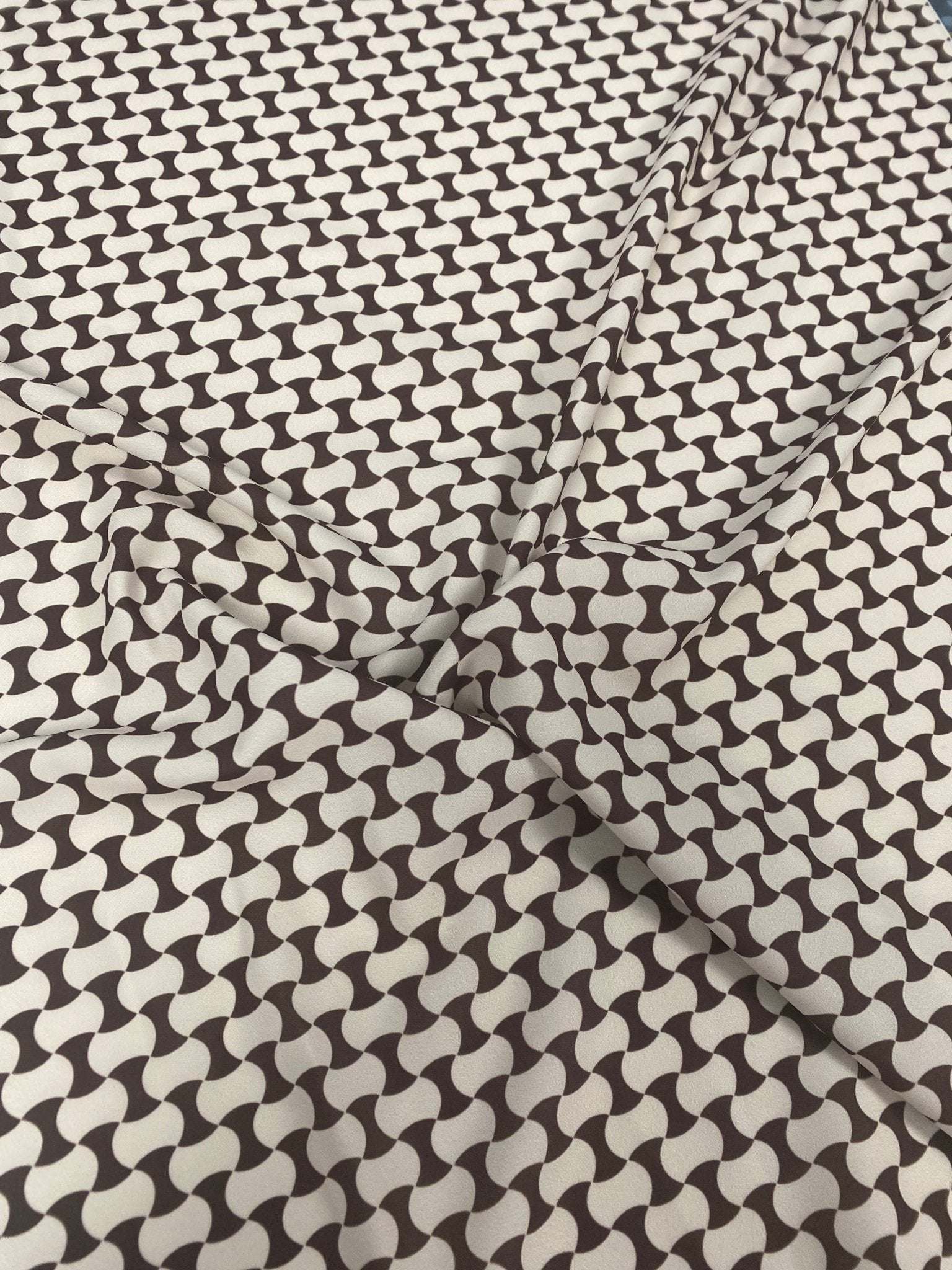 Close-up of geometric black and white optical illusion fabric with interlocking wave pattern and soft texture