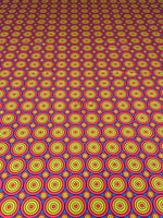 Colorful geometric circles print fabric with bright concentric circle patterns in yellow, red, and blue tones, perfect for sewing projects.