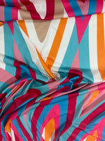 Colorful geometric print fabric with teal, orange, pink, and beige shapes in a soft texture