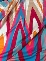 Soft geometric print fabric with colorful bold zigzag patterns in pink, blue, orange, and brown tones.