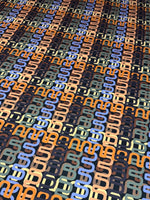 Geometric retro chain link pattern fabric in blue, orange, beige, and black for sewing and crafting projects