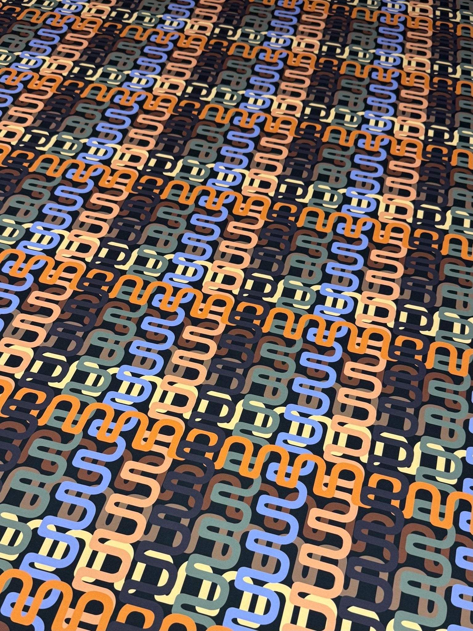 Geometric retro chain link pattern fabric in blue, orange, beige, and black for sewing and crafting projects