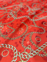Orange fabric with gold chain design pattern and circular accents