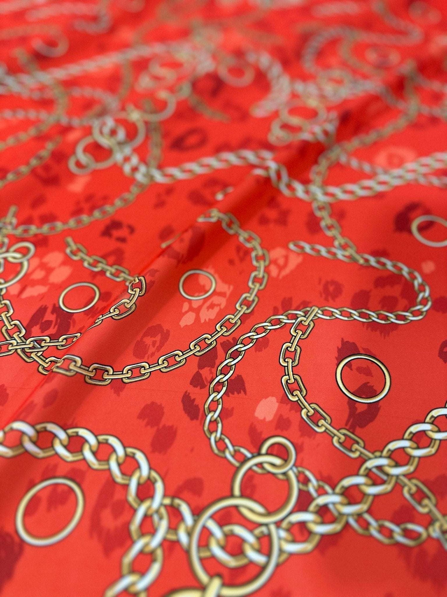 Orange fabric with gold chain design pattern and circular accents