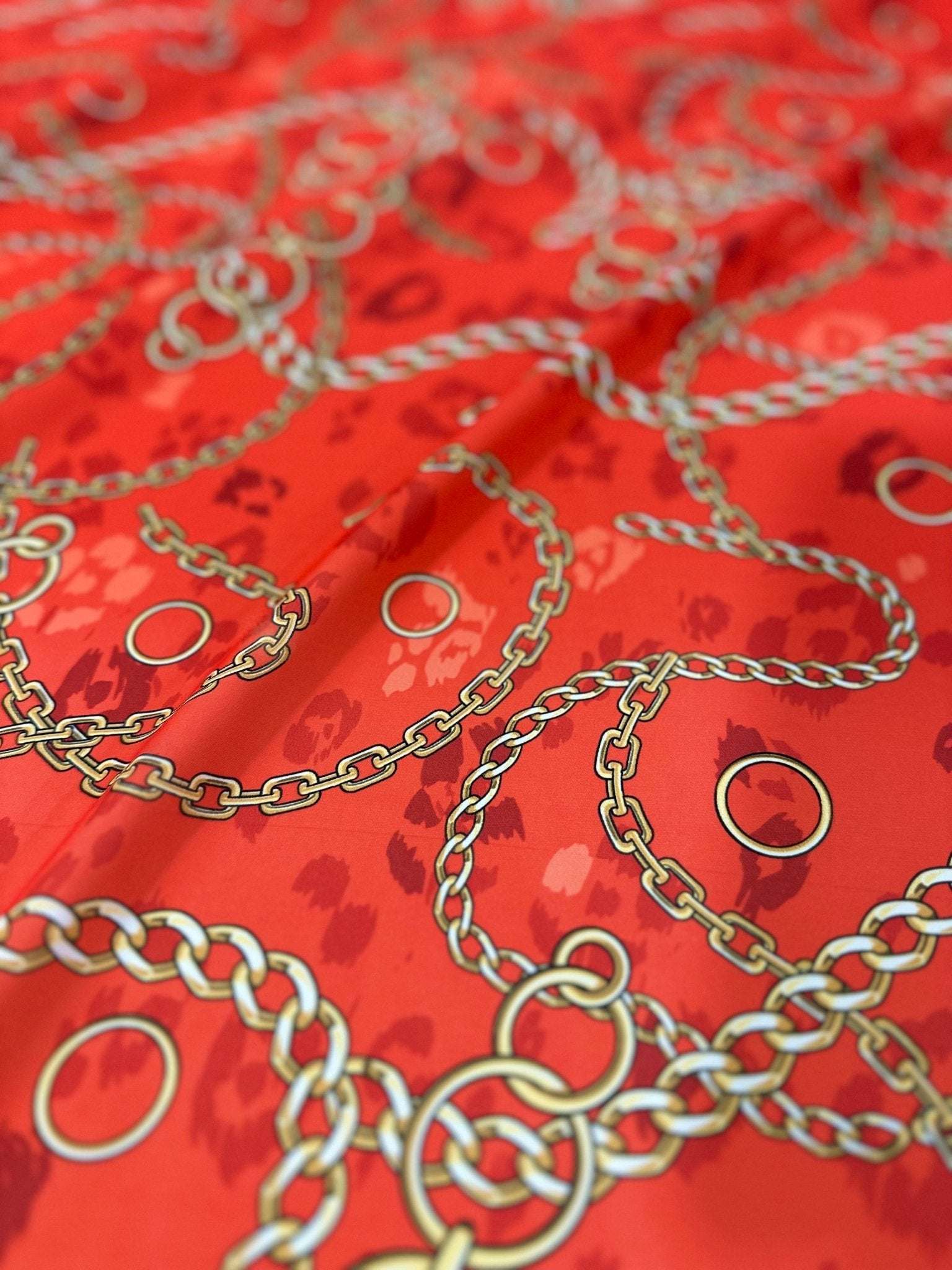 Orange fabric with gold chain design pattern and circular accents