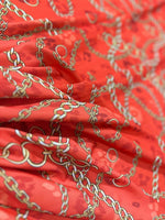 orange fabric with gold chain design pattern in close-up texture view