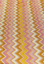 Pink orange zigzag glitter stretch fabric with gold Lurex threads and vibrant zigzag pattern