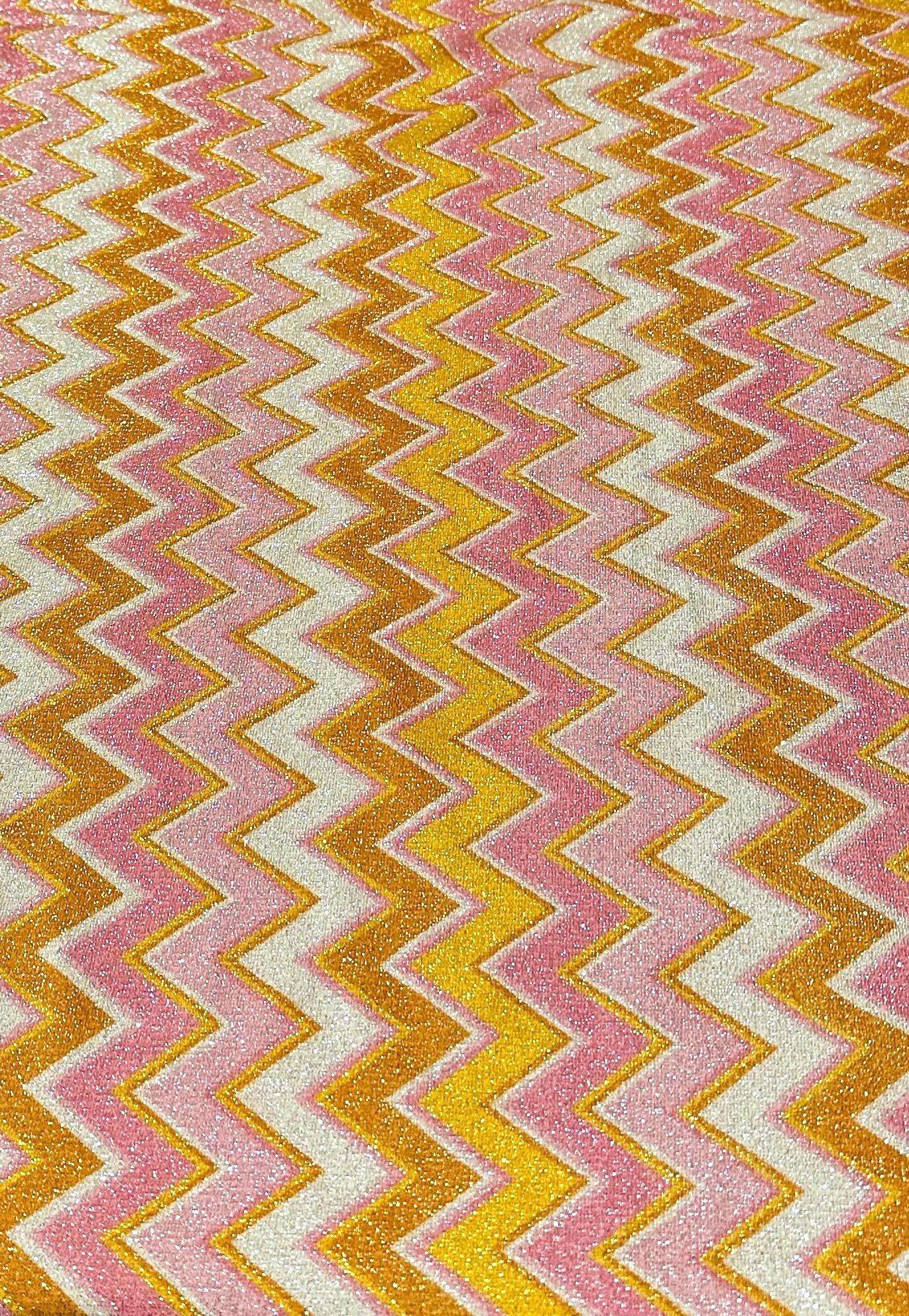 Pink orange zigzag glitter stretch fabric with gold Lurex threads and vibrant zigzag pattern