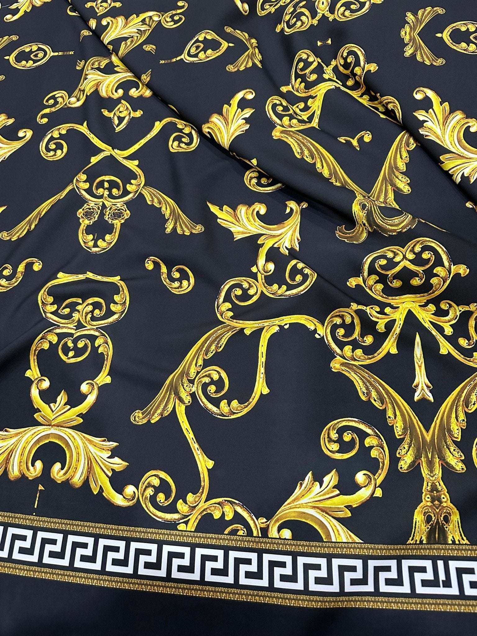 Black fabric with ornate gold Greek key and baroque pattern and white Greek key border design