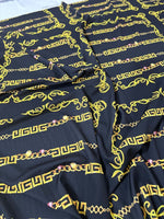Black fabric with gold Greek key and chain pattern design