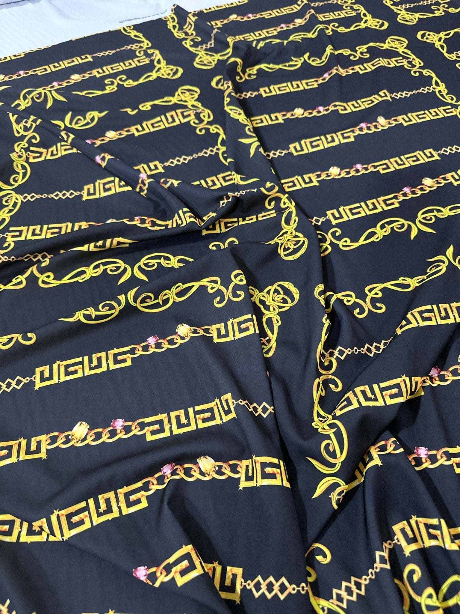 Black fabric with gold Greek key and chain pattern design