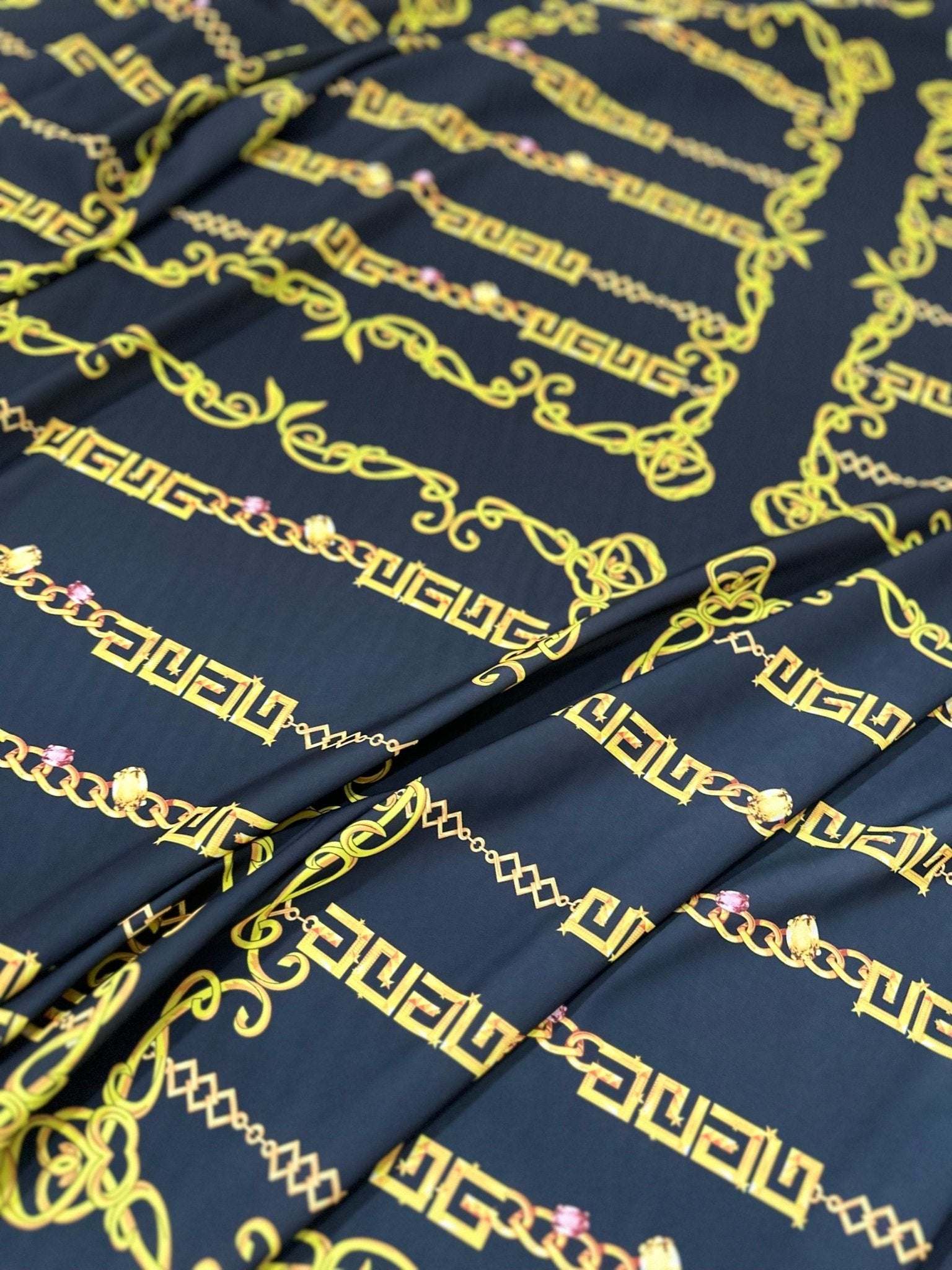 Black fabric with gold Greek key chain pattern detail by the yard