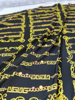 Black fabric with gold Greek key chain pattern for upholstery and fashion projects