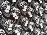 Black and white Greek crepe fabric featuring repeated classical Roman profile designs and intricate patterns