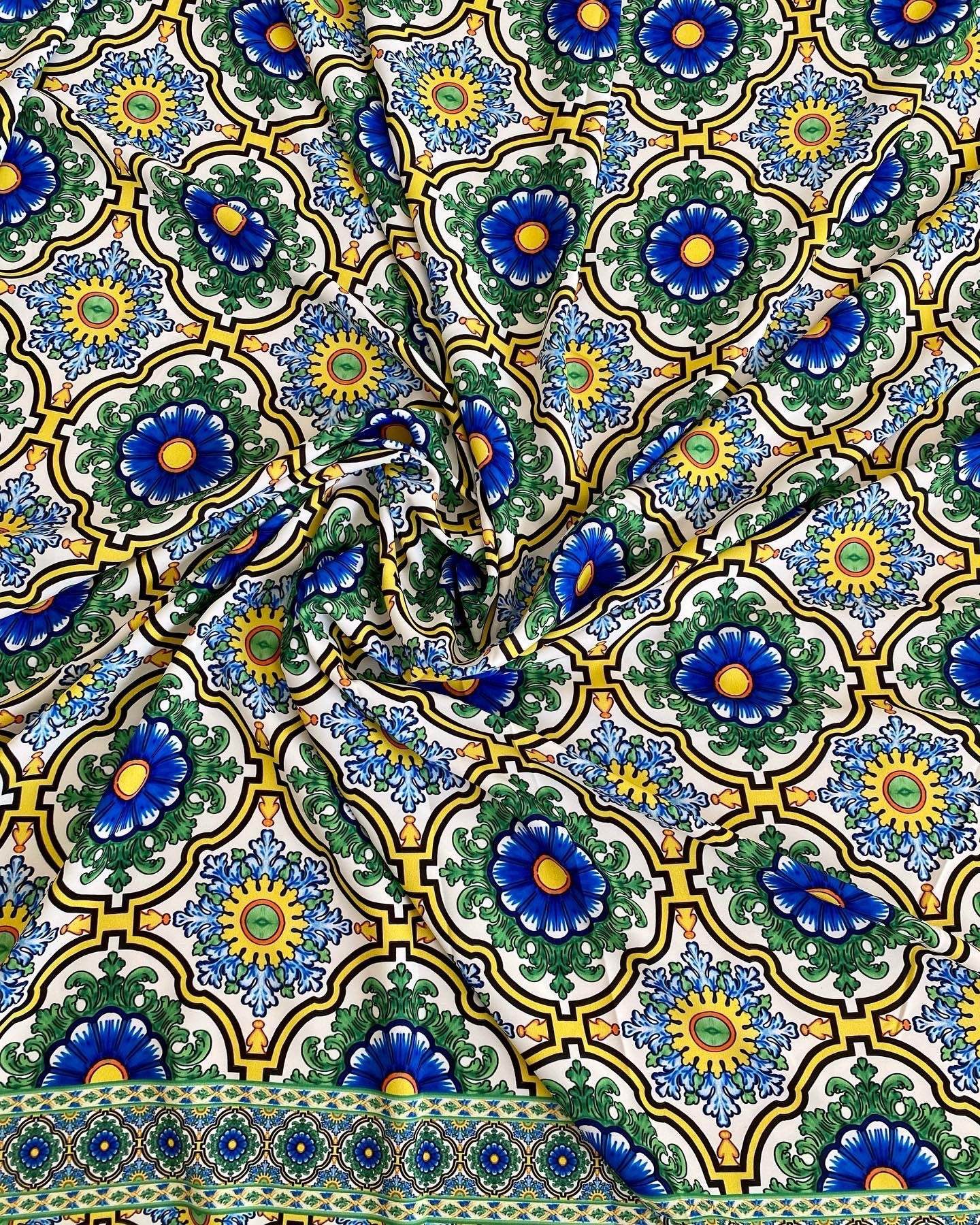 Sicilian pattern green fabric with blue and yellow floral motifs on a white background, 150cm wide textile for sewing and upholstery.