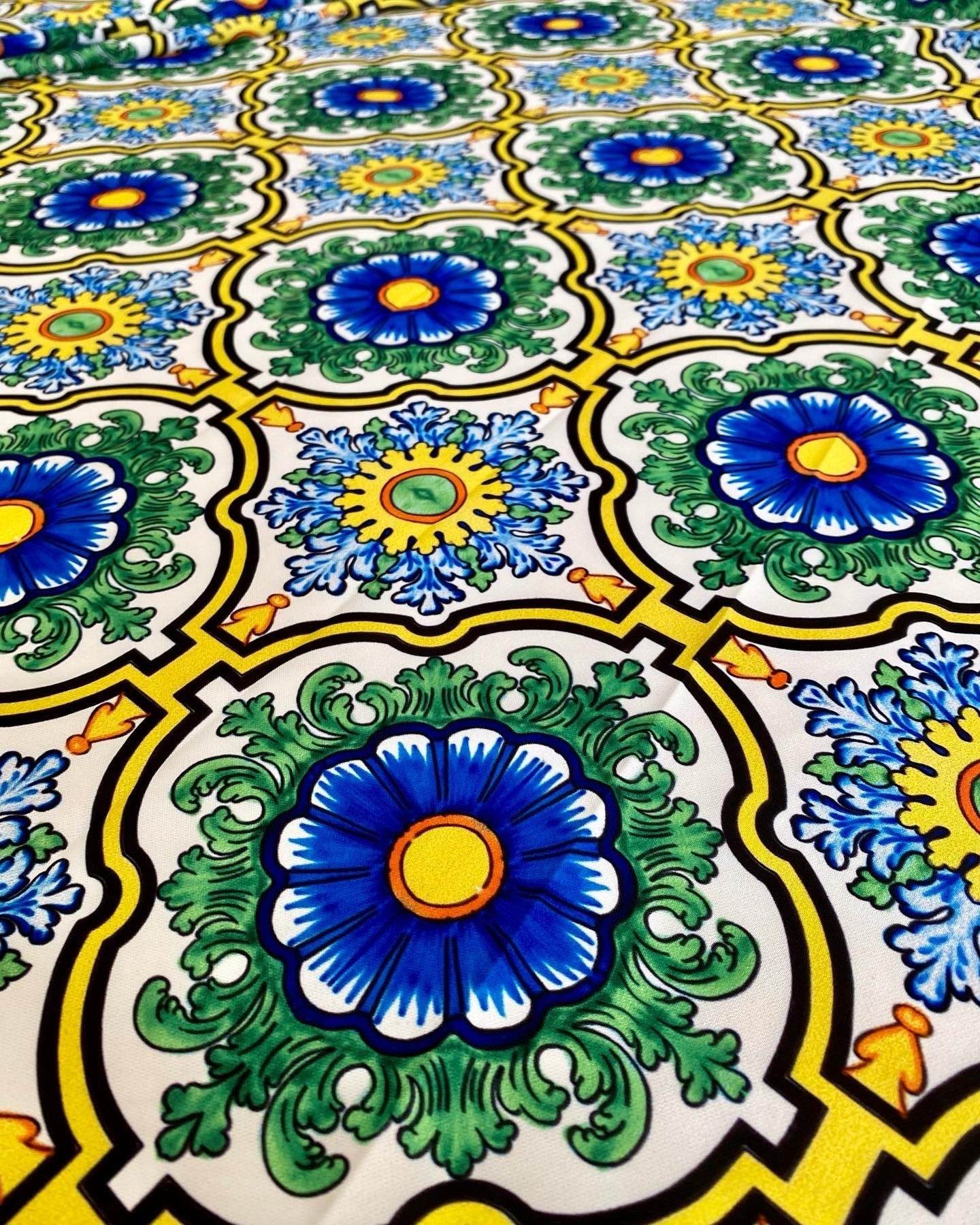 Sicilian pattern fabric with vibrant green, blue, and yellow floral designs on a white background
