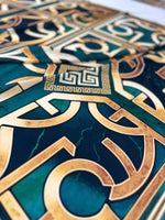 close-up of green gold crepe silky fabric with Greek key pattern and smooth texture