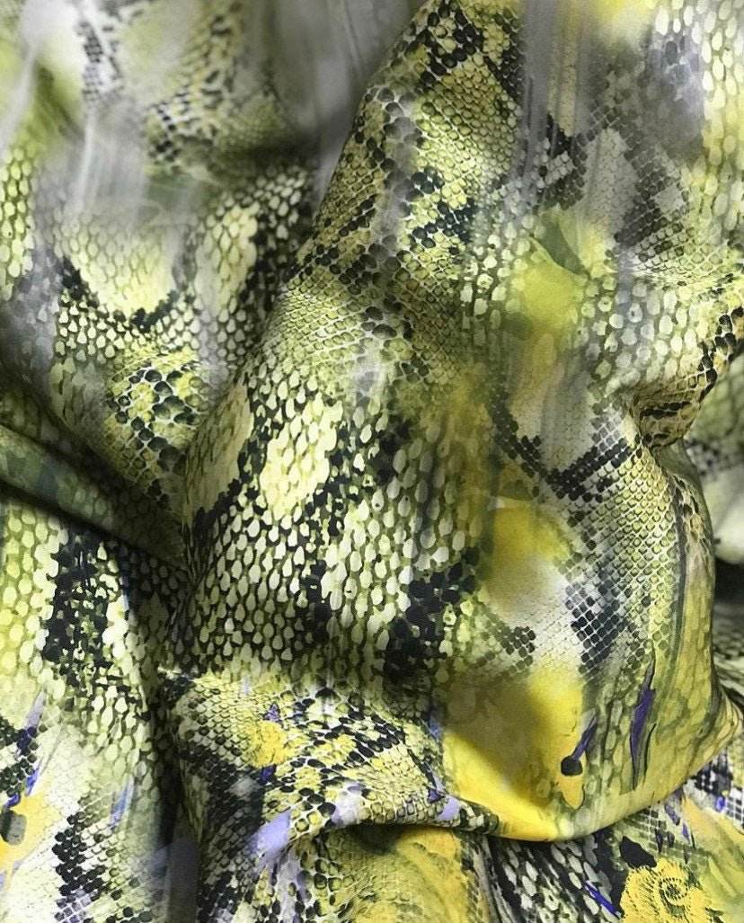 Green snake skin fabric with textured snake scale pattern in shades of yellow and black, 150cm width, suitable for fashion, upholstery, and crafts.