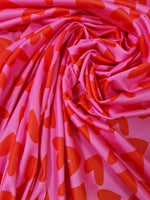 Pink cotton fabric with red heart print pattern, soft and ideal for sewing projects